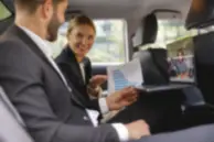 Business professionals discussing reports during a chauffeur-driven executive journey