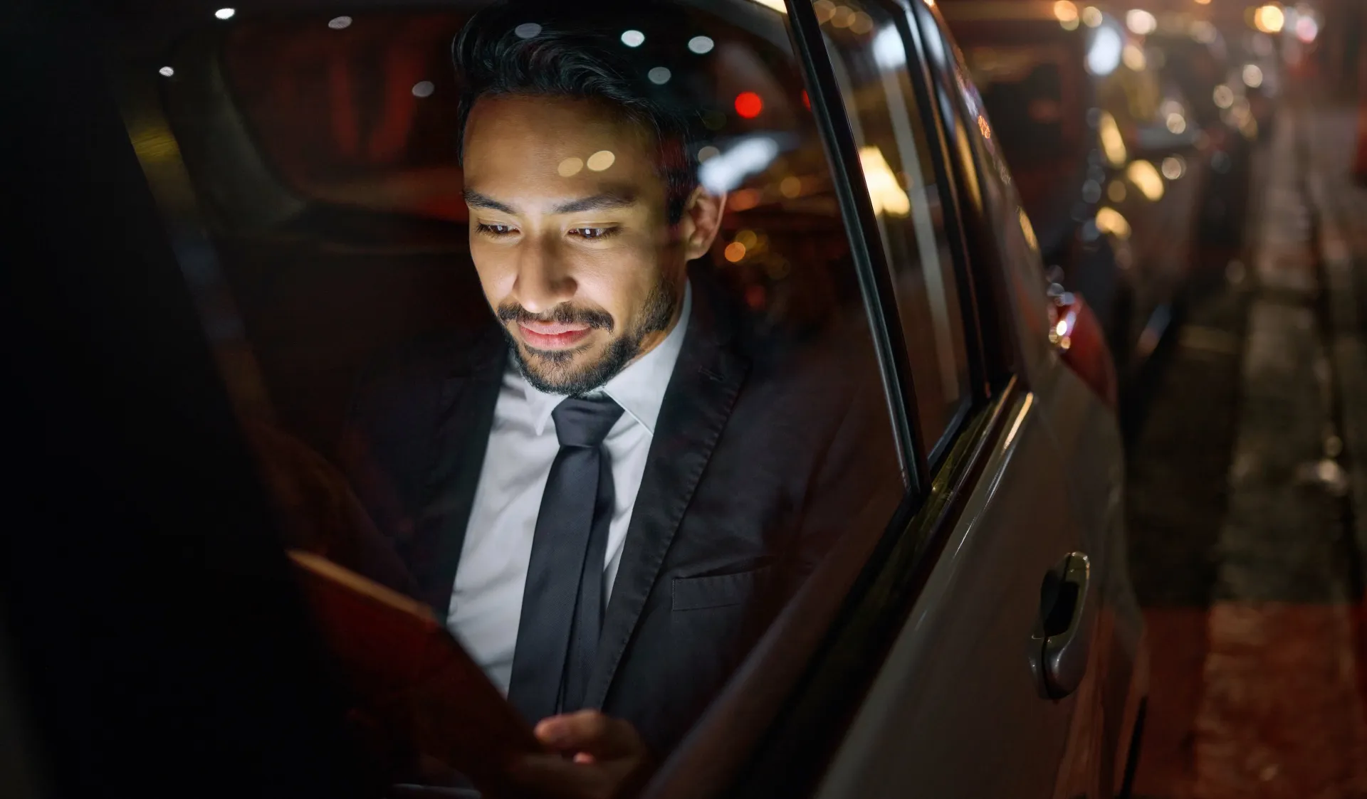 Business executive checking messages during a premium chauffeur service