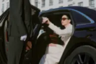 Chauffeur assisting a passenger during a luxury chauffeur service pickup