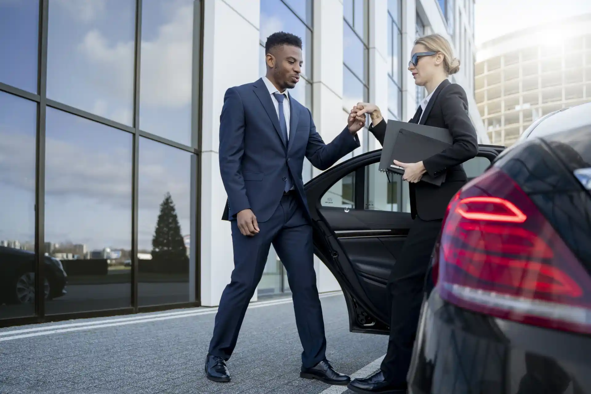 Executive protection team escorting a client from a luxury SUV in an urban business district