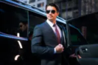 Business executive stepping out of a luxury chauffeur vehicle