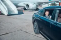 A passenger just came out of the aeroplane and boarded a luxury chauffeur car