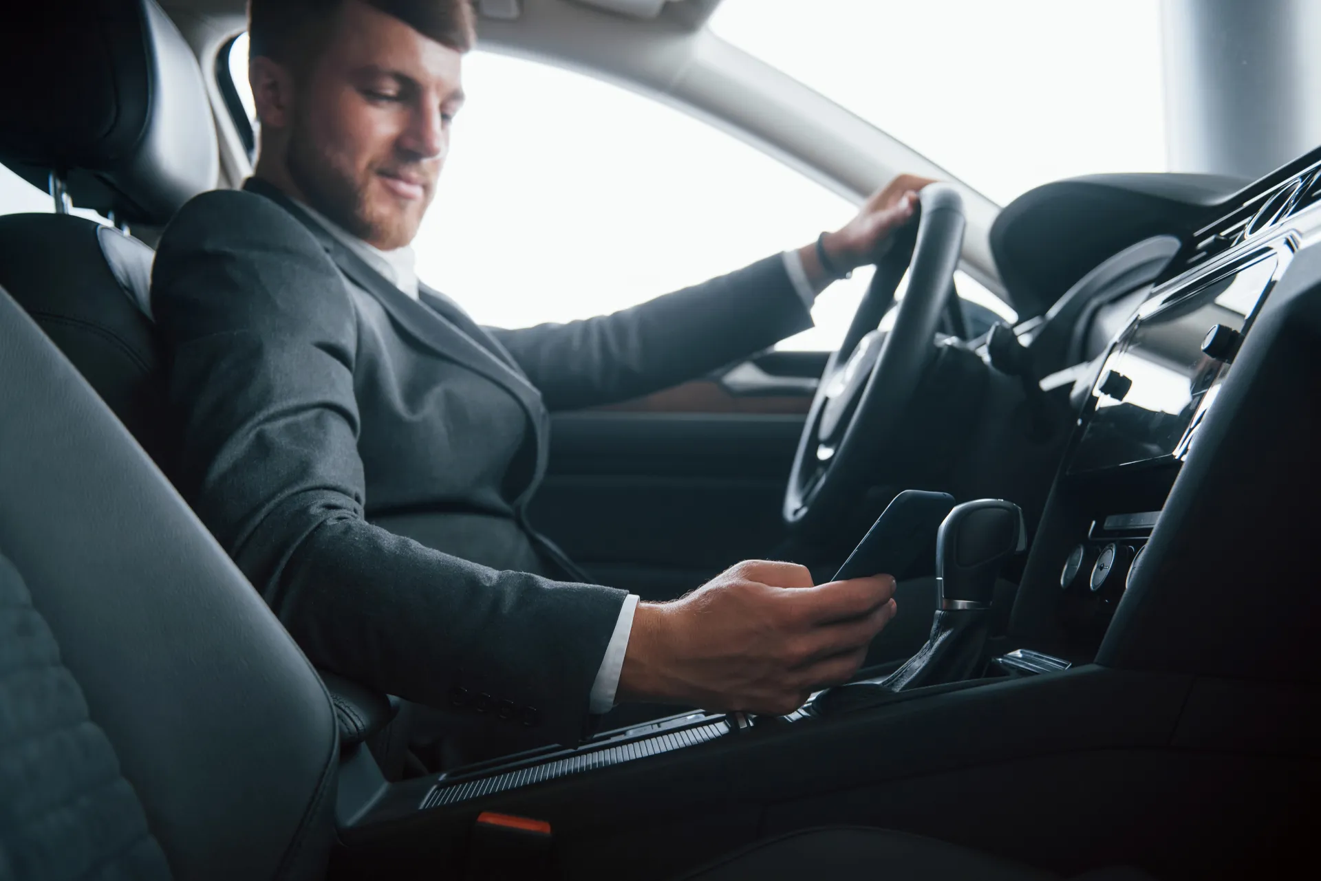 Professional chauffeur adjusting vehicle controls before an executive journey