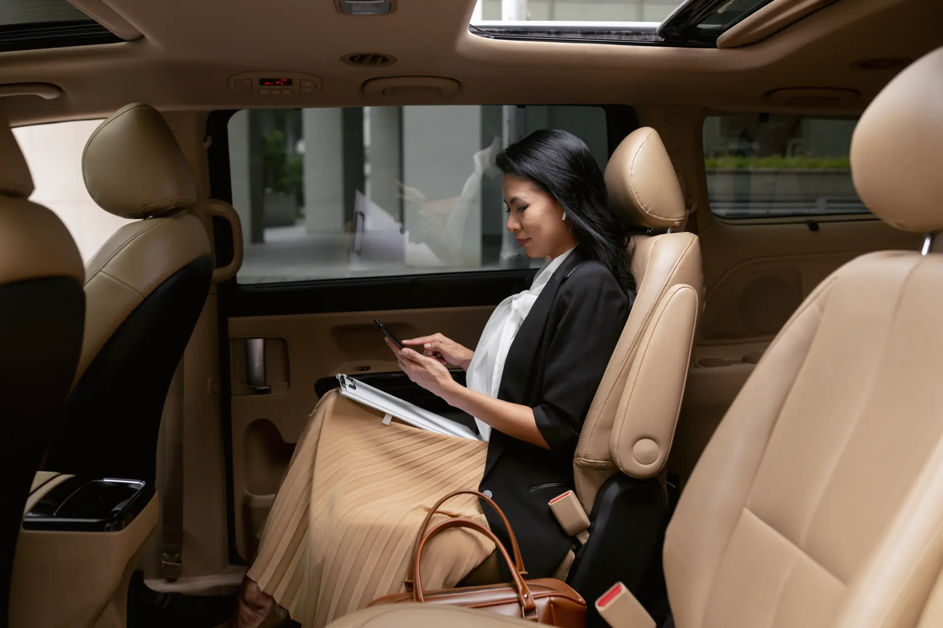 Passenger enjoying a comfortable journey in a luxury chauffeur-driven vehicle