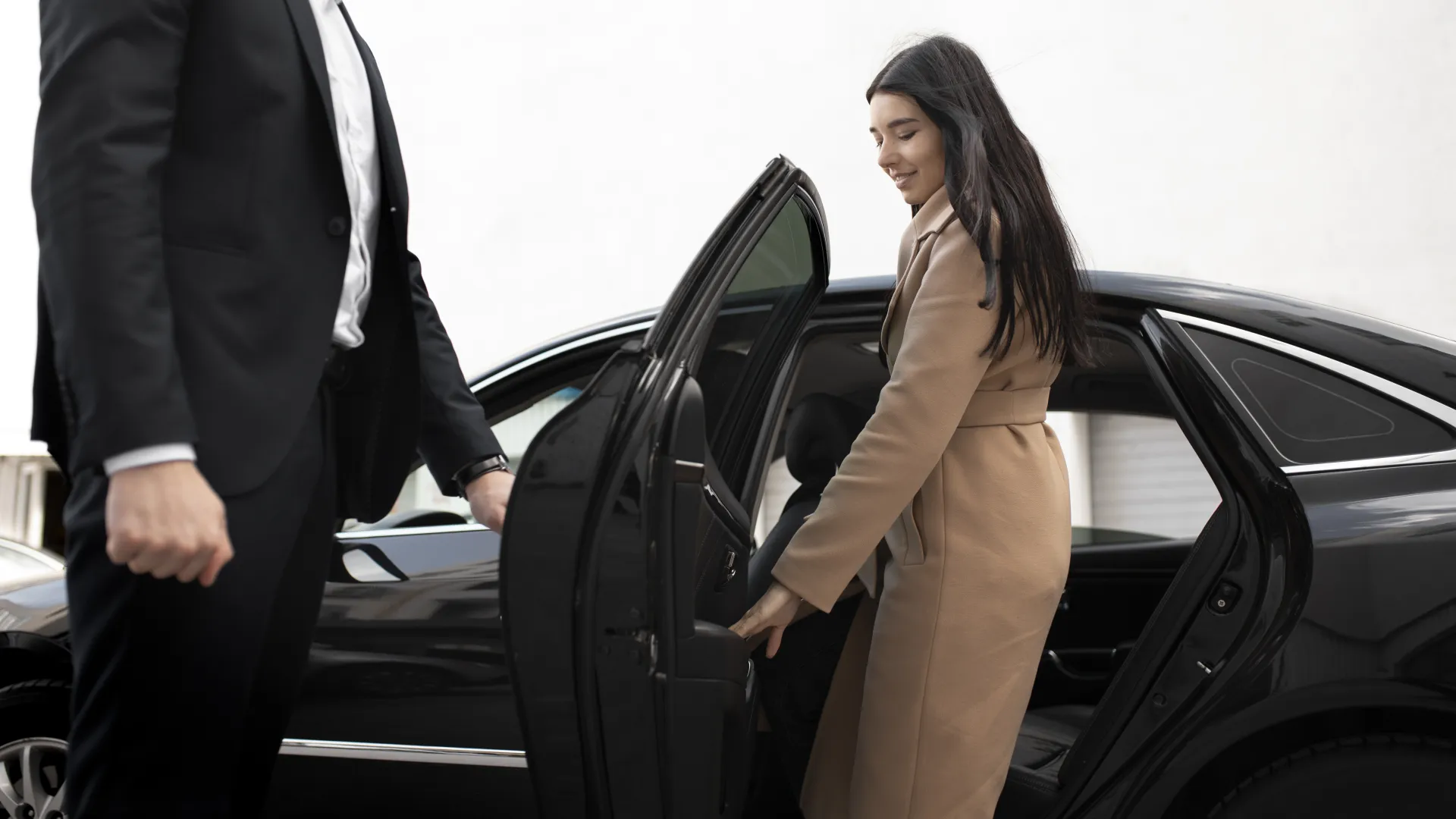 Professional chauffeur opening the car door for a passenger