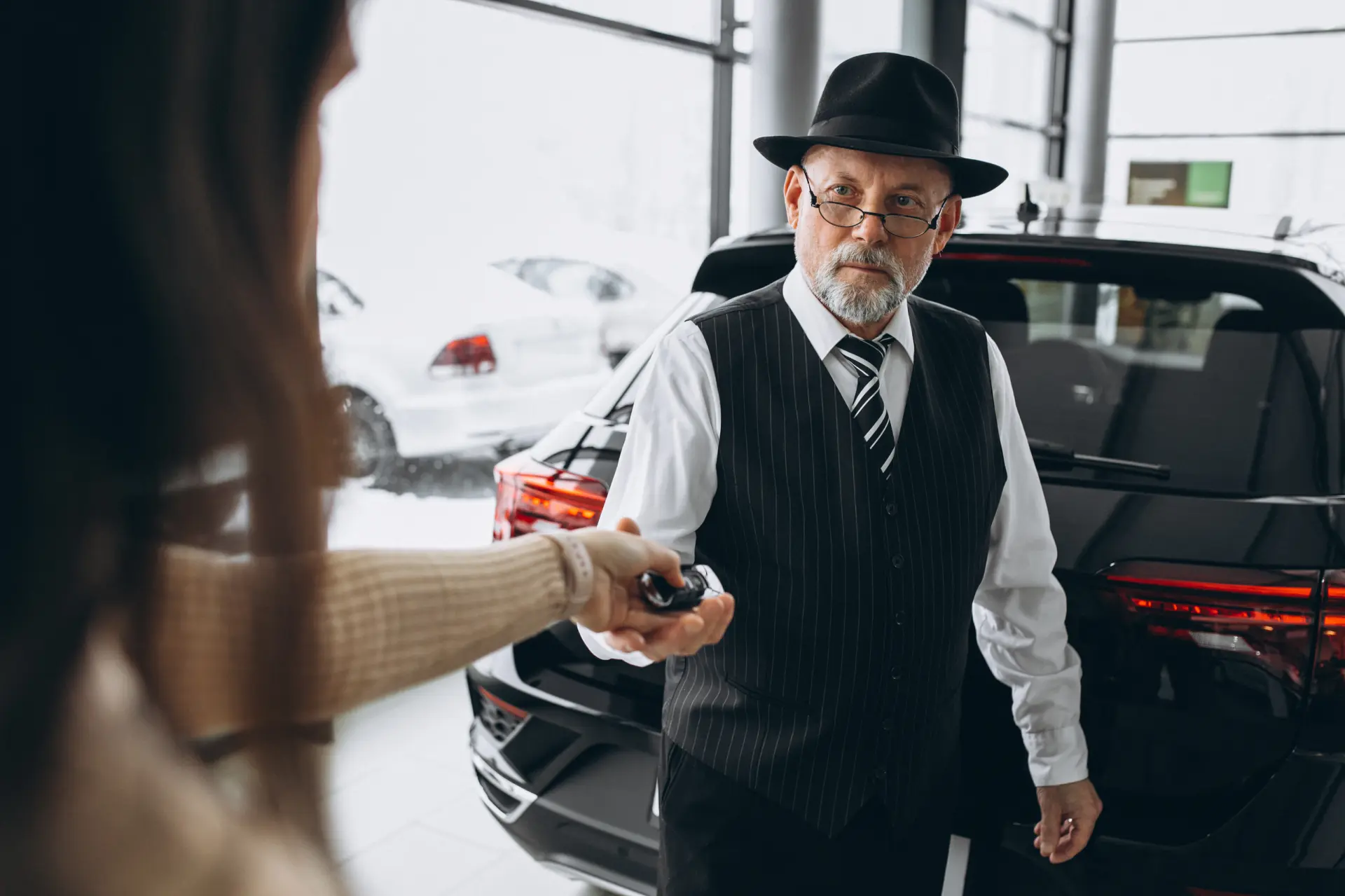 Professional chauffeur receiving car keys before an executive chauffeur service