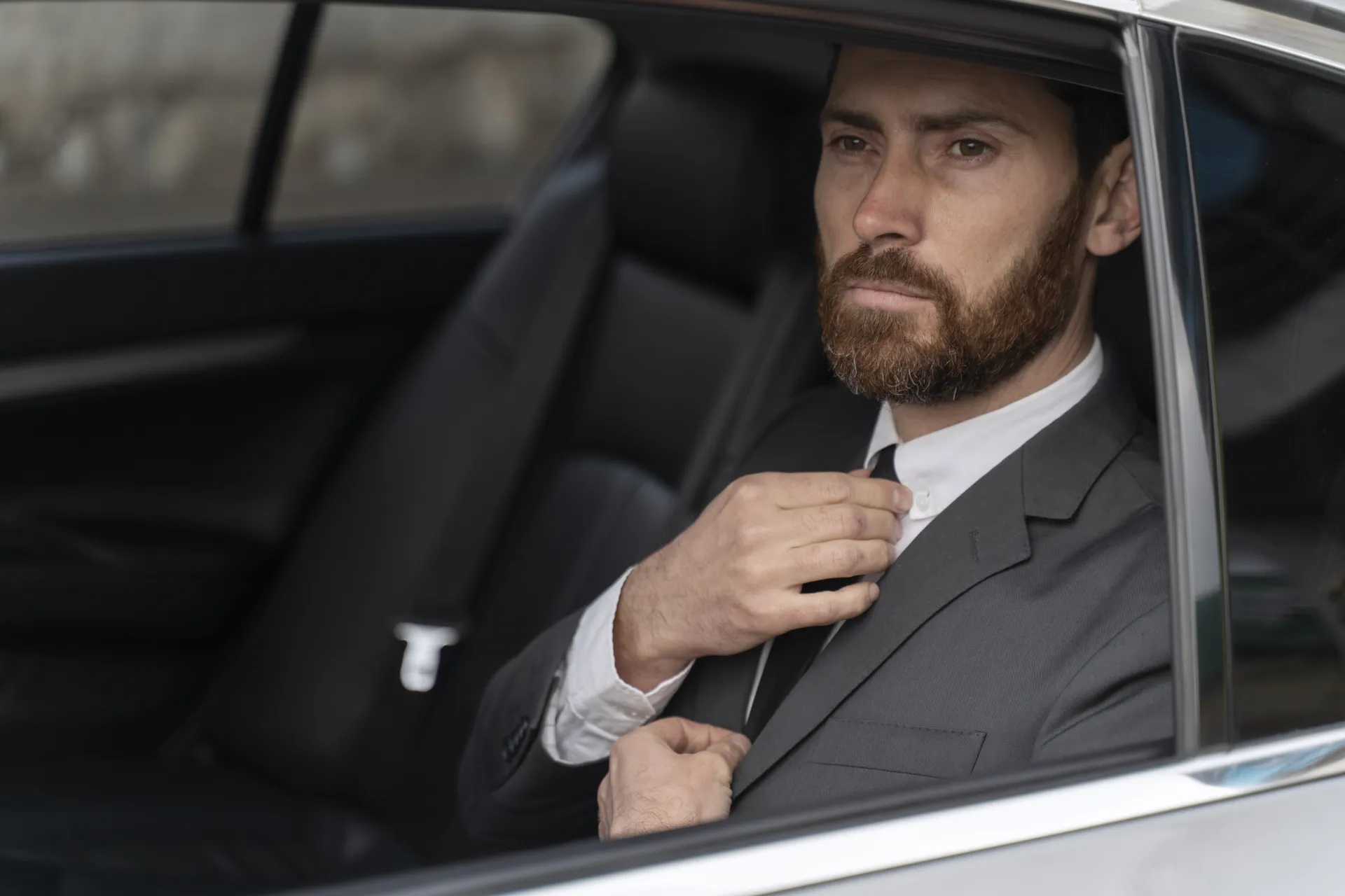 Business executive preparing for a meeting inside a luxury chauffeur-driven car